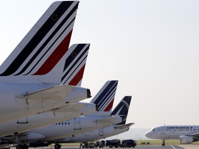 FILE - In this Sept.15, 2014 file photo, Air France planes are parked on the tarmac of the Paris Charles de Gaulle airport, in Roissy, near Paris. France's national air company management is meeting Monday with unions worried female cabin crew could be disciplined if they refuse to work the company's new route to Iran, for which they must wear a headscarf. (AP Photo/Christophe Ena)