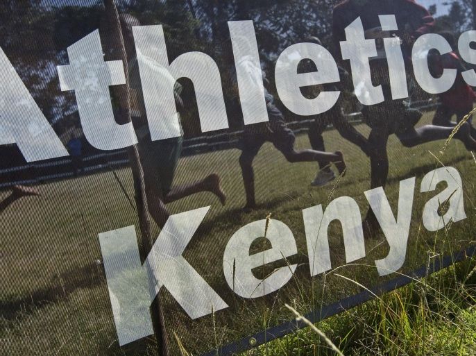 FILE - In this Sunday, Jan. 31, 2016, photo from files, junior athletes run past a sign for Athletics Kenya at the Discovery cross country races in Eldoret, western Kenya. Kenya’s sports minister said Tuesday, April 19, 2016 that a long-awaited anti-doping law has been passed by the country’s parliament and now only needs to be signed by the president - legislation that must be in place by May 2 to beat a final deadline set by the World Anti-Doping Agency. (AP Photo/Ben Curtis, File)