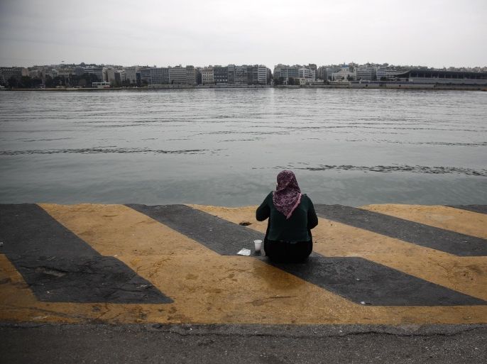 A woman speaks on the phone as she sits at a promenade of the port of Piraeus, near Athens, on Saturday, April 2, 2016. Greece is pressing ahead with plans to start deporting migrants and refugees back to Turkey next week, despite mounting concern from the United Nations and human rights organizations that Syrians could be denied proper protection while some are allegedly even being forced back into their war-torn country. (AP Photo/Yorgos Karahalis)