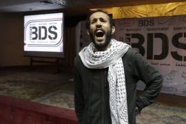 FILE - In this Monday, April 20, 2015 file photo, An Egyptian man shouts anti-Israeli slogans in front of banners with the Boycott, Divestment and Sanctions (BDS) logo during the launch of the Egyptian campaign that urges boycott, divestment and sanctions against Israel and Israeli-made goods, at the Egyptian Journalists’ Syndicate in Cairo, Egypt. The presidents of Israel's eight research universities are calling on an American organization to refrain from moving forward with plans to boycott Israeli academics. The initiative is backed by BDS, which aims to protest Israeli policies toward the Palestinians but which Israeli universities accuse of spreading lies and slander about the country. (AP Photo/Amr Nabil, File)