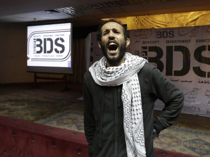 FILE - In this Monday, April 20, 2015 file photo, An Egyptian man shouts anti-Israeli slogans in front of banners with the Boycott, Divestment and Sanctions (BDS) logo during the launch of the Egyptian campaign that urges boycott, divestment and sanctions against Israel and Israeli-made goods, at the Egyptian Journalists’ Syndicate in Cairo, Egypt. The presidents of Israel's eight research universities are calling on an American organization to refrain from moving forward with plans to boycott Israeli academics. The initiative is backed by BDS, which aims to protest Israeli policies toward the Palestinians but which Israeli universities accuse of spreading lies and slander about the country. (AP Photo/Amr Nabil, File)