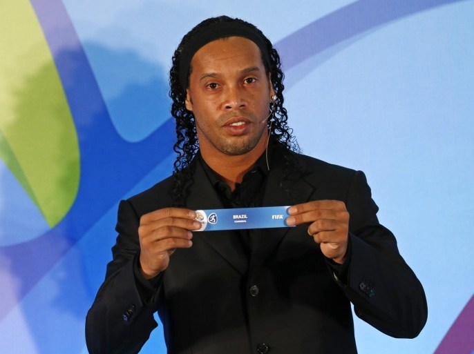 Brazil's soccer player Ronaldinho holds up a paper reading "Brazil" during the draw for the men's Olympic football tournament in Rio de Janeiro, Brazil, Thursday, April 14, 2016. Brazil will face South Africa in the opening game of the men’s Olympic football tournament as the five-time World Cup champions try for their first Olympic gold medal in the sport. Brazil lost the Olympic final to Mexico four years ago in London. (AP Photo/Silvia Izquierdo)