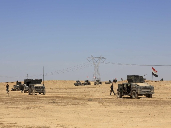 Iraq's elite counter terrorism forces advance through soft desert terrain outside the western Islamic State held town of Hit, 85 miles (140 kilometers) west of Baghdad, Iraq, Sunday, April 3, 2016. Iraqi forces said Sunday that they have taken the northern edge of the Islamic State group held town of Hit, after hundreds of roadside bombs littering the surrounding area slowed progress for days. (AP Photo/Khalid Mohammed)