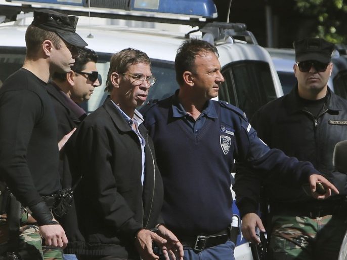Cyprus police officers escort EgyptAir plane hijacking suspect Seif Eddin Mustafa, third right, to a court for a remand hearing as authorities investigate him on charges including hijacking, illegal possession of explosives and abduction in the Cypriot coastal town of Larnaca Wednesday, March 30, 2016. The Egyptian man described as "psychologically unstable" hijacked a flight Tuesday from Egypt to Cyprus and threatened to blow it up. His explosives turned out to be fake, and he surrendered with all passengers released unharmed after a bizarre six-hour standoff. (AP Photo/Petros Karadjias)