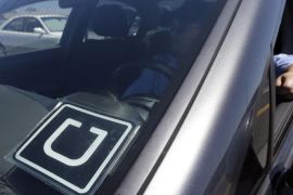 FILE - In this July 15, 2015, file photo, Uber driver Karim Amrani sits in his car parked near the San Francisco International Airport parking area. Uber said Thursday, April 7, 2016, it will pay at least $10 million to settle a case in which California prosecutors alleged it misled passengers over the quality of its driver background checks. (AP Photo/Jeff Chiu, File)