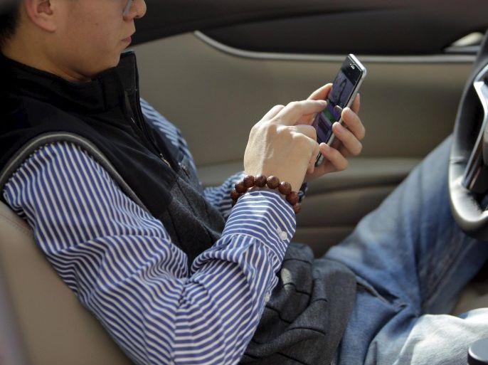 Mr Kang, a fan of online hostess Sun Xiaohou, chats with Sun by text on his mobile phone in a car during a live broadcast in Beijing April 3, 2015. In China's online hostessing world, men find virtual company and the women can find riches. Sun is one of more than 10,000 hostesses on the internet site bobo.com, a live broadcasting web platform where anyone can record themselves singing, playing piano, dancing or just chatting. REUTERS/Jason Lee PICTURE 27 OF 27 FOR WIDER IMAGE STORY ‘CHINA’S ONLINE HOSTESSES’SEARCH 'XIANGGONG’ FOR ALL IMAGES