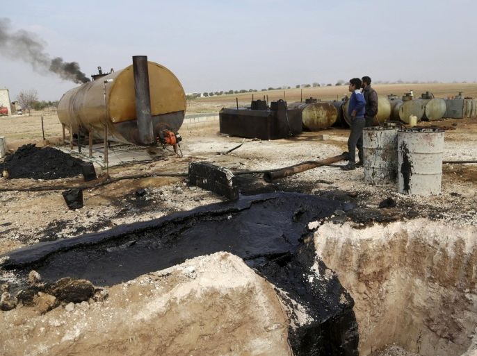 Men work at a makeshift oil refinery site in Marchmarin town, southern countryside of Idlib, Syria in this December 16, 2015, file photo. The refinery site, owned by Yousef Ayoub, 34, has been active for 4 months. Ayoub says that he gets the crude oil from Islamic State-controlled areas in Deir al-Zor province and Iraq. Islamic State has set up departments to handle "war spoils," including slaves, and the exploitation of natural resources such as oil, creating the trappings of government that enable it to manage large swaths of Syria and Iraq and other areas. REUTERS/Khalil Ashawi