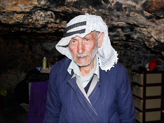 أبو نائل يقطن مع أسرته بكهف ويعتبر نفسه محظوظا لنجاته من الهدم الإسرائيلي (الجزيرة)