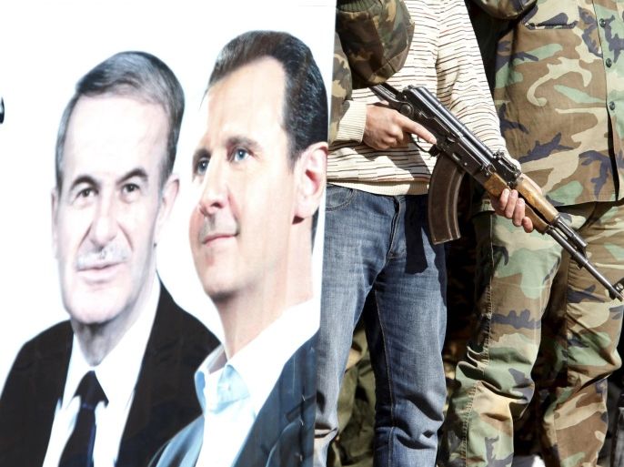 Syrian civilians who volunteered to join local Self Protection Units to protect their neighbourhoods alongside the Syrian army attend training near a picture of Syria's president Bashar al-Assad and his father late former president Hafez al-Assad, in Damascus countryside, Syria December 5, 2015. REUTERS/Omar Sanadiki