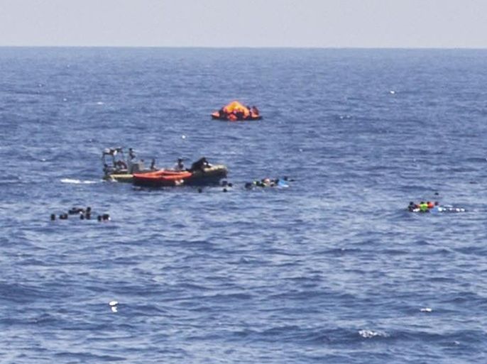 RECROPPED VERSION OF MSF101 - The scene of the capsizing and sinking of a fishing boat crowded with migrants is seen from the deck of the Dignity I MSF search and rescue vessel which responded to the emergency in the Mediterranean sea off Libya, Wednesday, Aug. 5, 2015. The Italian coast guard and Irish navy said at least 367 people were saved, although 25 bodies also were found in the latest human smuggling tragedy. (Marta Soszynska/MSF via AP)
