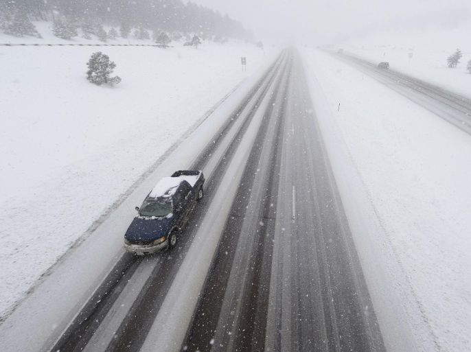 A lone pickup truck heads down the eastbound lanes of Interstate 70 as a severe spring storm packing high winds and heavy, wet snow sweeps over the intermountain West Saturday, April 16, 2016, near Evergreen, Colo. While the storm is starting later than predicted, forecasters are expecting driving snow to pummel the region Saturday night into Sunday, which has already forced the cancellation of hundreds of flights out of Denver's airport. (AP Photo/David Zalubowski)