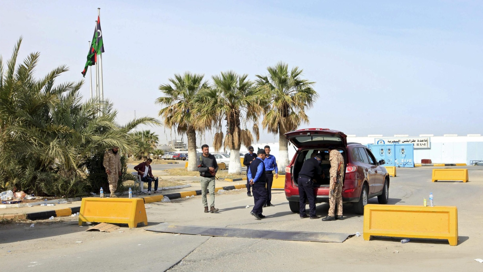 قوات أمن تابعة لحكومة الوفاق تفتش سيارة أمام مدخل مكاتبها (رويترز)