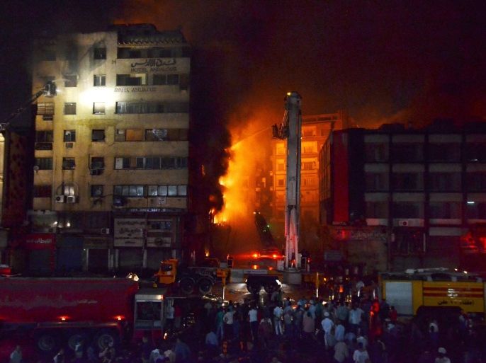 Egyptian firefighters try to extinguish a fire that broke out in a small hotel (L) before spreading to several buildings in Cairo, Egypt, 09 May 2016. According to reports, 50 people were injured, including firefighters, when an overnight fire at a small hotel in Ataba neighborhood spread to other buildings and markets in the old area of Cairo. EPA/AYMAN AREF EGYPT OUT