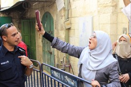 مرابطة فلسطينية تبرز القرآن الكريم في وجه شرطي إسرائيلي بعد منعها من دخول الأقصى.