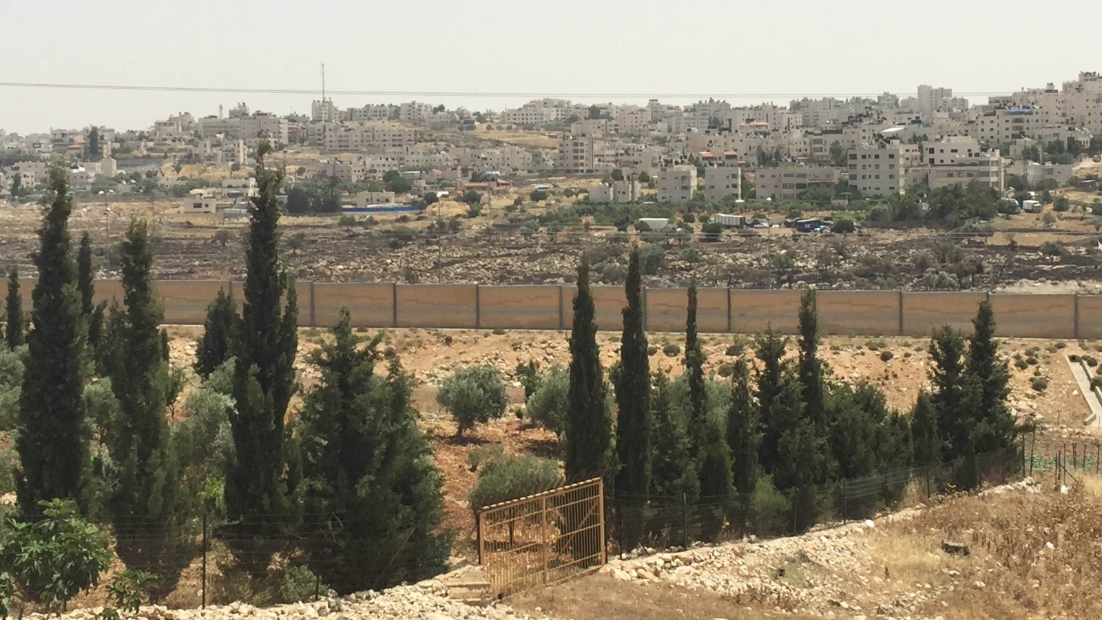 الجدار الإسرائيلي العازل قسم بلدة بت حنينا إلى شطرين (الجزيرة)
