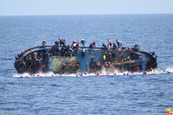 Migrants are seen on a capsizing boat before a rescue operation by Italian navy ships "Bettica" and "Bergamini" off the coast of Libya in this handout picture released by the Italian Marina Militare on May 25, 2016. Marina Militare/Handout via REUTERS ATTENTION EDITORS - THIS PICTURE WAS PROVIDED BY A THIRD PARTY. FOR EDITORIAL USE ONLY.