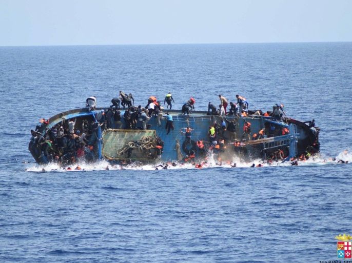 Migrants are seen on a capsizing boat before a rescue operation by Italian navy ships "Bettica" and "Bergamini" off the coast of Libya in this handout picture released by the Italian Marina Militare on May 25, 2016. Marina Militare/Handout via REUTERS ATTENTION EDITORS - THIS PICTURE WAS PROVIDED BY A THIRD PARTY. FOR EDITORIAL USE ONLY.