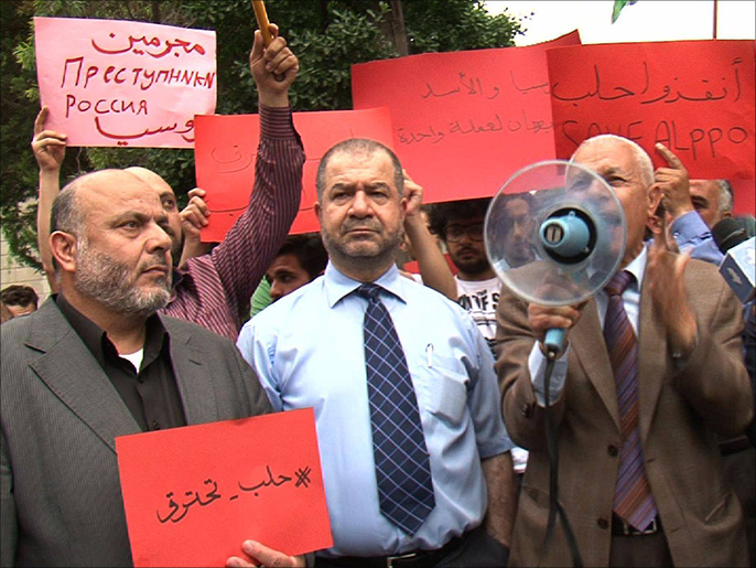 ‪‬ المشاركون في الفعالية رفعوا لافتات تندد بقصف حلب(الجزيرة)
