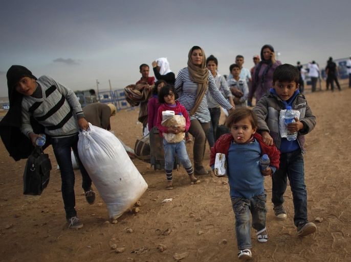 Kurdish Syrian refugees carry their belongings after crossing the Turkish-Syrian border near the southeastern town of Suruc in Sanliurfa province in this September 25, 2014 file photo. Reuters photographers have chronicled Kurdish refugee crises over the years. In 1991 Srdjan Zivulovic documented refugees in Cukurca who had escaped a military operation by Saddam Hussein's government in Iraq aimed at "Arabising" Kurdish areas in the north. Hundreds of thousands fled into Turkey and Iran. Images shot in recent months show familiar scenes as crowds of people flee Islamic State militants in Syria. There are as many as 30 million Kurds, spread through Turkey, Iraq, Syria and Iran. Most Kurds are Sunni Muslims, but tend to feel more loyalty to their Kurdishness, rather than their religion. REUTERS/Murad Sezer/Files (TURKEY - Tags: SOCIETY IMMIGRATION POLITICS CONFLICT) ATTENTION EDITORS: PICTURE 04 OF 30 PICTURES FOR WIDER IMAGE STORY 'KURDISH REFUGEES - THEN AND NOW'SEARCH 'CUKURCA' FOR ALL IMAGES