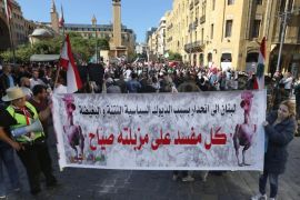 Activists from the "You Stink" anti-government movement hold a banner with Arabic that reads, "Lebanon is heading downward because of the filthy and hated political roosters. Every corrupt (politician) sits over his trash," during a right-wing Christian Phalange Party protest near the parliament building in downtown Beirut, Lebanon, Thursday, Nov. 12, 2015. Supporters of the Phalange Party protested Thursday outside the parliament building demanding that the legislature elect a new president rather than draft new laws. (AP Photo/Bilal Hussein)