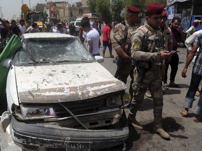 Security forces and citizens inspect the scene after a car bomb explosion at a crowded outdoor market in the Iraqi capital's eastern district of Sadr City, Iraq, Wednesday, May 11, 2016. An explosives-laden car bomb ripped through a commercial area in a predominantly Shiite neighborhood of Baghdad on Wednesday, killing and wounding dozens of civilians, a police official said. (AP Photo/ Khalid Mohammed)