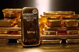 Gold bars are stacked at a safe deposit room of the ProAurum gold house in Munich in this March 6, 2014 file picture. Gold climbed above $1,300 an ounce on January 21, 2015 for the first time since August as a softer dollar, worries about the global economy and hopes of stimulus measures from the European Central Bank (ECB) fuelled demand. REUTERS/Michael Dalder/Files (GERMANY - Tags: BUSINESS COMMODITIES)