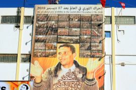 a giant portrait of tunisian protestor mohamed bouazizi hangs on the wall in the central town of sidi bouzid on december 17, 2013, as they celebrate the 3rd anniversary of the start of the revolution, the first of the arab spring uprisings, triggered by the self-immolation of bouazizi, the vegetable vendor harassed by poverty and police atrocity. tunisians gathered today at the birthplace of the arab spring to vent their anger at social exclusion three years