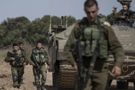 Israeli soldiers walk by a tank near the Israel Gaza border, Wednesday, May 4, 2016. The Israeli army says a tank has fired at a target in the northern Gaza Strip following an explosion on the Palestinian side of the border. The army says it's trying to determine the source of the explosion, which took place on Wednesday. Earlier, a tank fired into Gaza after a mortar shell was launched toward Israeli forces near the southern Gaza Strip. (AP photo/Tsafrir Abayov)