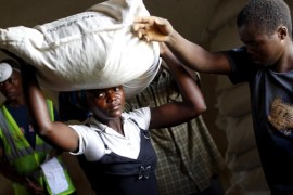 A woman carries food aid distributed by the United Nations World Food Progamme (WFP) in Mzumazi village near Malawi's capital Lilongwe, February 3, 2016. REUTERS/Mike Hutchings/File Photo