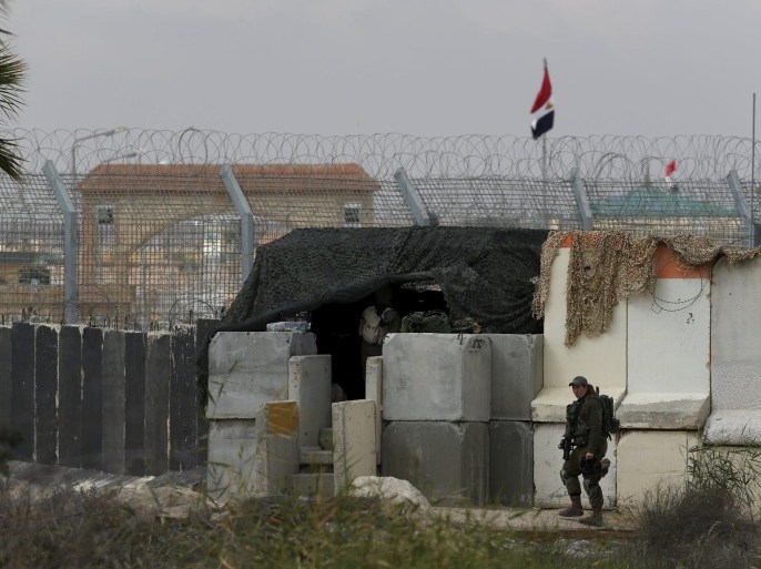 An Israeli soldier stands next to concrete barriers near Israel's border fence with Egypt's Sinai peninsula, in Israel's Negev Desert February 10, 2016. REUTERS/Amir Cohen