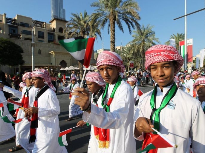 Emiratis school boys wave the UAE flags during the Downtown Dubai Parade at the Emaar Boulevard street in Gulf emirate of Dubai, United Arab Emirates on 02 December 2012. UAE citizens and the residents celebrate on each 2nd of December from each year in occasion of the UAE National Day which marks the unification of the seven emirates : Abu Dhabi, Dubai, Sharjah, Fujairah, Ras al-Khaimah, Ajman and Umm al-Quwain in one strong state which is United Arab Emirates, and the UAE freedom from the British Protectorate.