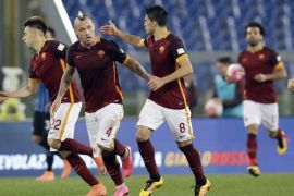 Roma's Radja Nainggolan, center, celebrates with his teammates after scoring during a Serie A soccer match between Roma and Inter Milan, at Rome's Olympic Stadium, Saturday, March 19, 2016. (AP Photo/Andrew Medichini)