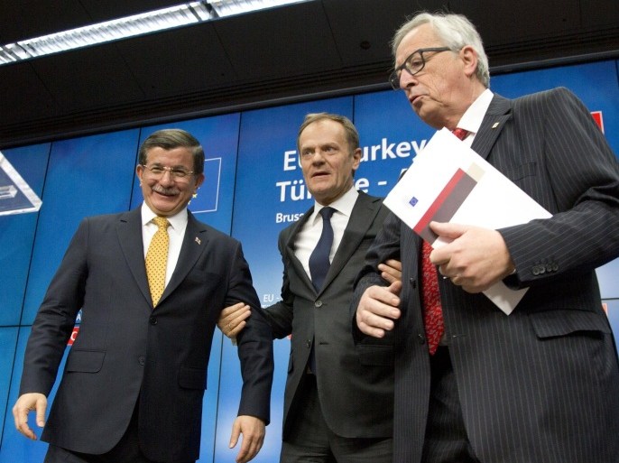 Turkish Prime Minister Ahmet Davutoglu, left, stands with European Council President Donald Tusk, center, and European Commission President Jean-Claude Juncker at the end of an EU summit in Brussels on Friday, March 18, 2016. The European Union and Turkey have reached a landmark deal to ease the migrant crisis and give Ankara concessions on better EU relations, The Czech prime minister announced Friday. (AP Photo/Virginia Mayo)