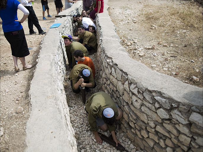 Israeli youths holding mock Israeli Uzis in an old Jordanian war trench at the 'Ammunition Hill memorial site and heritage of the battle for Jerusalem during the Six Day War (1967)' in Jerusalem, Israel, 29 May 2016