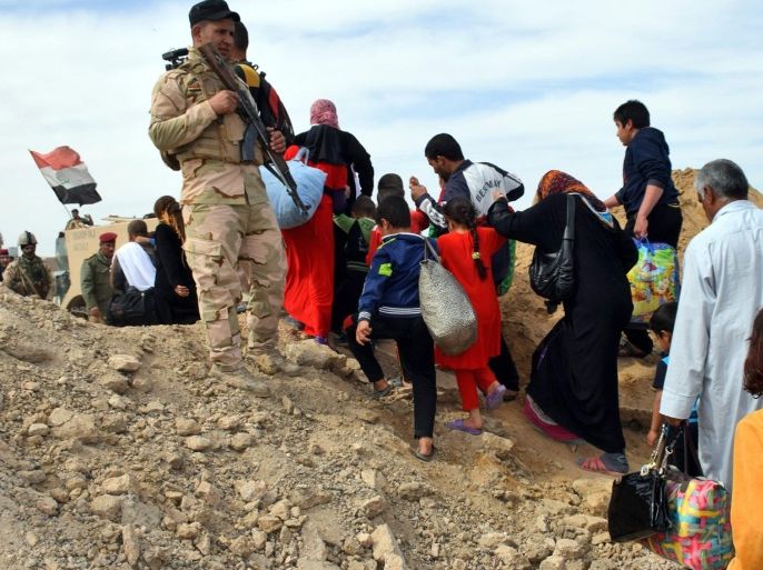 A photo made available on 10 March 2016 shows Iraqi soldiers observing the evacuation of families from the recently recaptured town of Zangura, near Ramadi city, western Iraq, on 09 March 2016. Iraqi forces backed by airstrikes from a US-led coalition have retaken Zangura town northeast of Ramadi as efforts to close in on the Fallujah city, which was seized by the Islamic State (IS) group in February 2014. According to Iraqi military officials, hundreds of families were