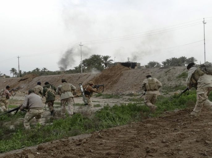 In this Friday, Jan. 22, 2016 photo, Iraqi security forces respond to an Islamic State group attack on their position in Ramadi, 70 miles (115 kilometers) west of Baghdad, Iraq. The Islamic State group, which controls large parts of Syria and Iraq where it declared an Islamic caliphate in June 2014, suffered several defeats recently in both countries, including the loss of the Iraqi city of Ramadi and parts of northern and northeastern Syria over the past months. (AP Photo)