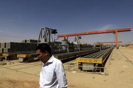 A Chinese man walks at Shanghai Hui Bo Investment Co (SHIC) for manufacturing railway cement sleepers and accessories in north Khartoum February 14, 2013. Sudan should become a transport route for some of South Sudan's oil production once the two countries can agree an arrangement.Work to renew the rail tracks started last year when China's Shanghai Hui Bo Investment Co (SHIC) opened a plant in north Khartoum, opposite the Sudanese capital's main train station, and i