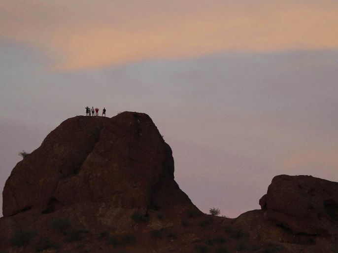 Men stand on top of a butte at Papago Park in Phoenix, Arizona, hoping for a better view of the "super Moon" May 5, 2012. A "super Moon" will light up Saturday's night sky in a once-a-year cosmic show, overshadowing a meteor shower from remnants of Halley's Comet, the U.S. space agency NASA said. The Moon will seem especially big and bright since it will reach its closest spot to Earth at the same time it is in its full phase, NASA said. REUTERS/Darryl Webb (UNITED STATES - Tags: ENVIRONMENT SOCIETY)