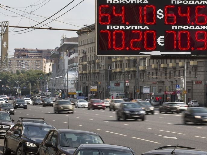 Cars drive past an exchange office sign showing the currency exchange rate in Moscow, Russia, Monday, Aug. 10, 2015. Official government figures show that the Russian economy contracted 4.6 percent in the second quarter from the same quarter the previous year in the wake of plummeting oil prices and Western sanctions. (AP Photo/Alexander Zemlianichenko)