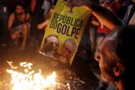 Members of Brazil's Homeless Workers' Movement (MTST), burn a poster with the images of President of the Brazilian Senate Renan Calheiros (L) and Brazil's interim President Michel Temer after the Brazilian Senate voted to impeach President Dilma Rousseff, at Paulista avenue in Sao Paulo, Brazil, May 12, 2016. The poster reads:" Republic of the Coup." REUTERS/Nacho Doce