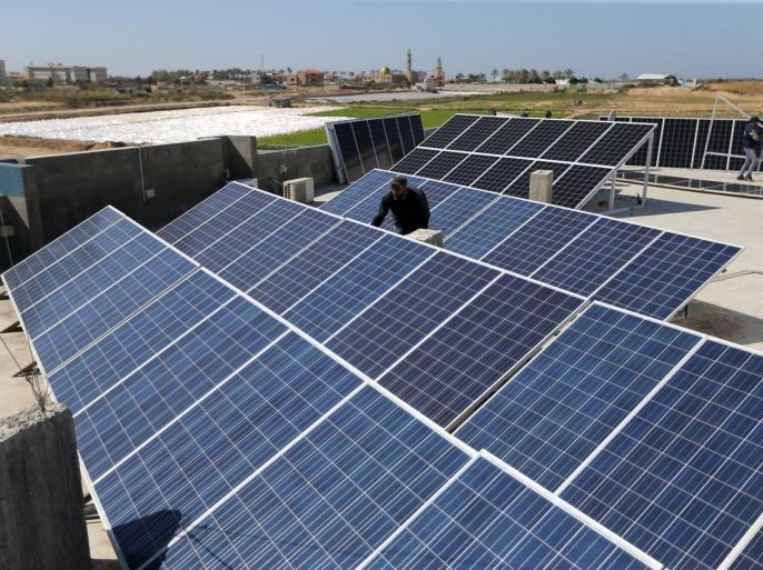 A Palestinian worker installs solar panels atop the roof of a medical centre in Gaza City March 1, 2016. REUTERS/Ibraheem Abu Mustafa