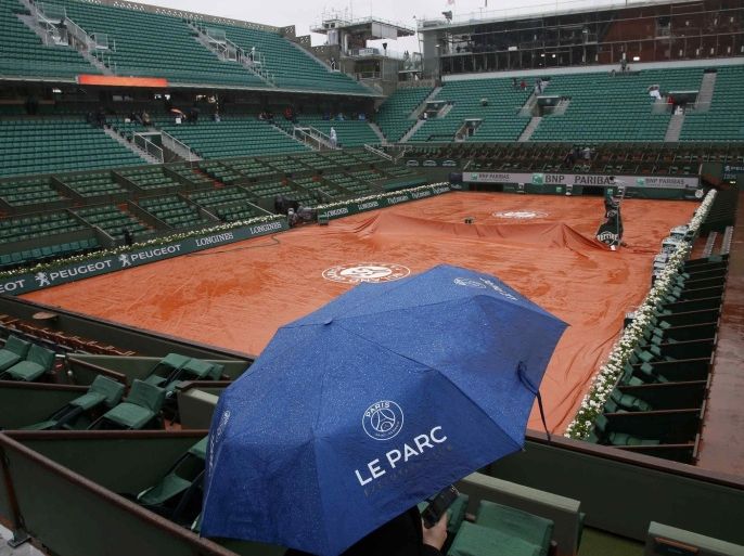 Tennis - French Open - Roland Garros- Paris, France - 30/05/16. A spectator uses an umbrella at the central court as rain falls in Paris. REUTERS/Pascal Rossignol