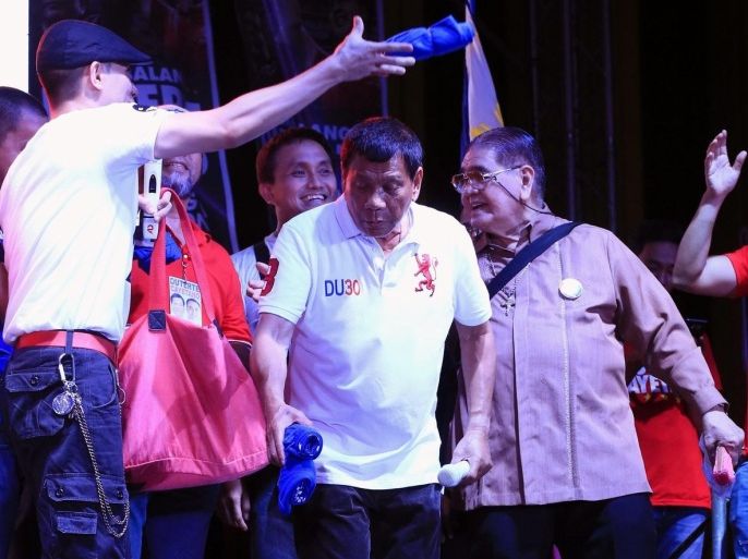 Filipino presidential candidate, Davao City Mayor Rodrigo Duterte (C) distributes t-shirts during an election campaign in Manila City, Philippines, 01 May 2016. Mayor of Davao and presidential candidate for the upcoming 09 May elections in the Philippines, Rodrigo Duterte, boasts openly of killing hundreds of criminals with the help of the so-called 'death squads' to reduce crime rate in the city that was once known as the most dangerous in the country.