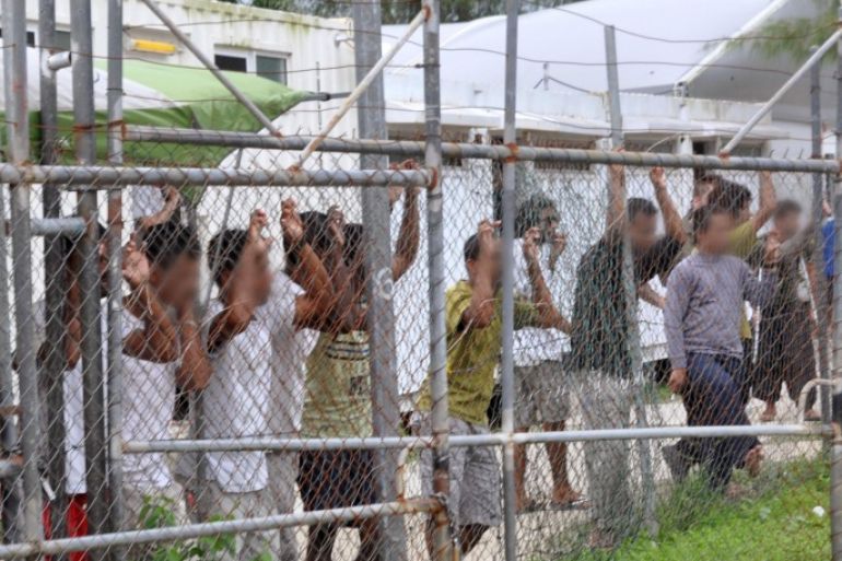 Asylum-seekers look through a fence at the Manus Island detention centre in Papua New Guinea March 21, 2014. AAP/Eoin Blackwell/via REUTERS ATTENTION EDITORS - THIS PICTURE WAS PROVIDED BY A THIRD PARTY. EDITORIAL USE ONLY. NO RESALES. NO ARCHIVE. AUSTRALIA OUT. NEW ZEALAND OUT.
