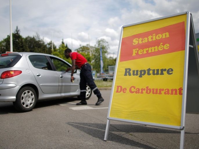 A security officer talks with a customer near a placard which reads "Out of Fuel" at a petrol station in Reze near Nantes, France, May 24, 2016. REUTERS/Stephane Mahe