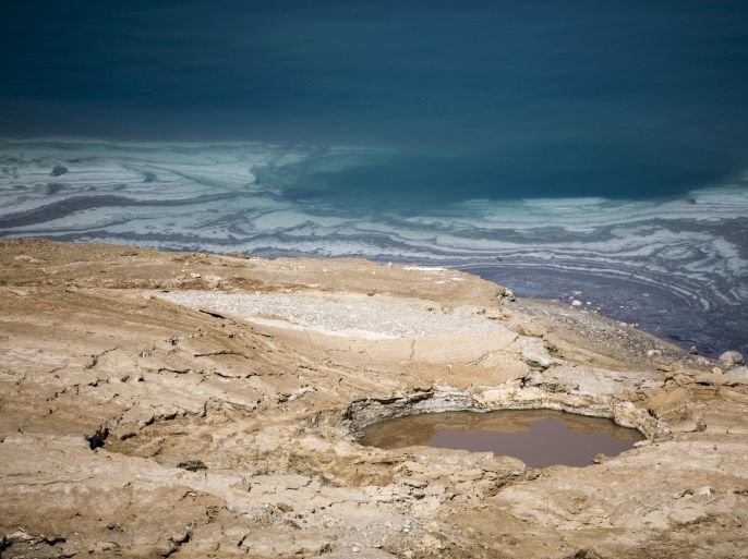 A sinkhole is seen on the shore of the Dead Sea near Kibbutz Ein Gedi, Israel July 27, 2015. The Dead Sea is shrinking, and as its waters vanish at a rate of more than one meter a year, hundreds of sinkholes, some the size of a basketball court, some two storeys deep, are devouring land where the shoreline once stood. Picture taken July 27, 2015. REUTERS/Amir Cohen