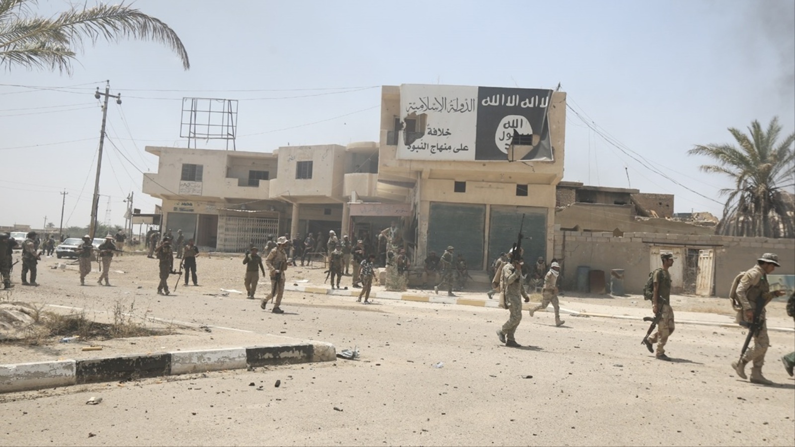 القوات العراقية في الخالدية إحدى ضواحي الفلوجة وتظهر فيها راية تنظيم الدولة (الأناضول)