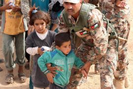(FILE) A file photograph dated 10 September 2015 showing Jordanian soldier helping Syrian refugees children upon their arrival at the Jordan Syria border point of Al-Rugban area in the north east of Jordan. According to military sources a car bomb in the early morning of 21 June 2016, exploded at the border with Syria, killing and wounding several Jordanian troops.