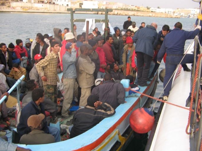 قارب يحمل مئات اللاجئين الارتريين والسوريين عند وصوله لجزيرة لامبيدوزا الإيطالية قادما من ليبيا . الجزيرة نت