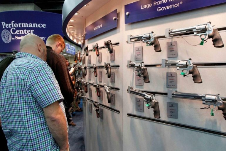 Gun enthusiasts look over Smith &amp; Wesson guns at the National Rifle Association's (NRA) annual meetings and exhibits show in Louisville, Kentucky, May 21, 2016. REUTERS/John Sommers II/File Photo